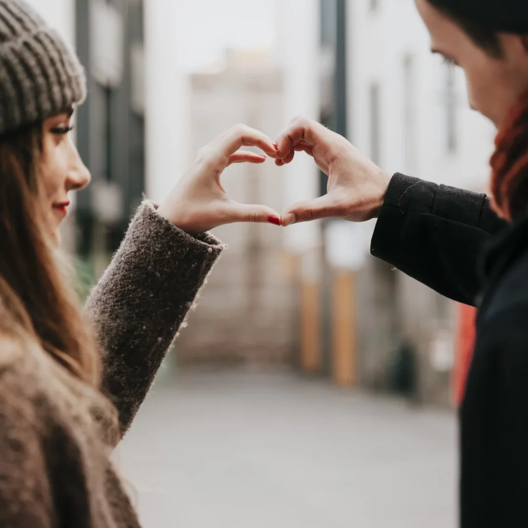 loving-couple-showing-hand-heart-gesture-min